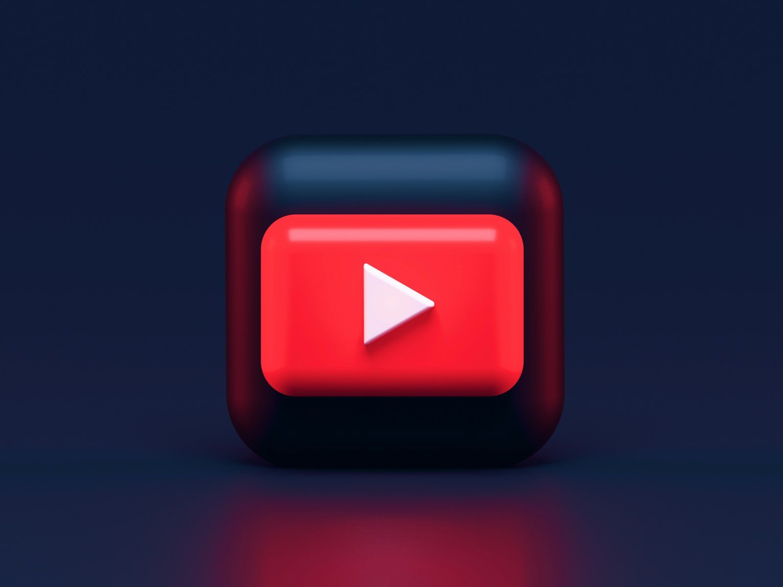 A 3D red play button icon on a dark blue background